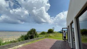 a person standing outside of a house looking at the ocean at ゴールデンマイルヴィラ in Amami