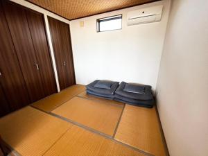 a room with a bed in the corner of a room at ゴールデンマイルヴィラ in Amami