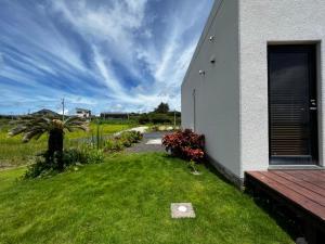 a house with a grass yard next to a building at ゴールデンマイルヴィラ in Amami