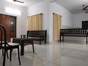 ein Wohnzimmer mit Bänken, einem Tisch und Stühlen in der Unterkunft Bachan's Casa The Private Pool Villa Cherai in Cherai Beach