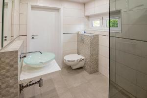 a bathroom with a sink and a toilet in it at Holiday Home by Dabrowa Wielka Lake in Wądzyn +12 photos