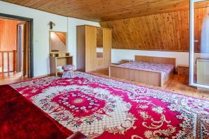 a large bedroom with a large red rug on the floor at Holiday Home by Dabrowa Wielka Lake in Wądzyn