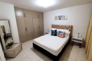 1 dormitorio con 1 cama con sábanas y almohadas blancas en Apartamento amoblado a 10 min del Parque del Café, en Montenegro