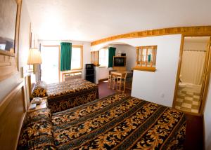 a hotel room with two beds and a living room at North Country Inn & Suites in Mandan