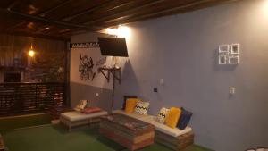 ein Wohnzimmer mit einem Sofa und einem Flachbild-TV in der Unterkunft Aylluwasihostel in Máncora