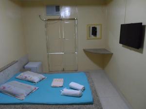 a room with a blue bed with towels on it at Hotel Avenida in Vitória