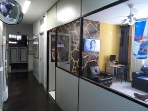 a hallway with a room with a couch and a tv at Hotel Avenida in Vitória