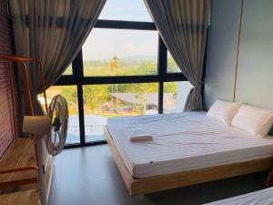 a bedroom with a bed and a large window at Chill Villa - Venuestay in Ba Vì
