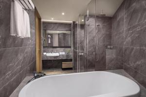 a bathroom with a bath tub and a shower at Somerset Zhongmao Changchun in Changchun