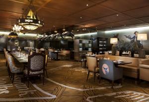 a restaurant with tables and chairs and a chandelier at SAHARA Las Vegas in Las Vegas