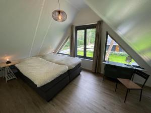 una camera con un letto e una grande finestra di Cosy energy friendly holiday home in a wooded area in Lochem a Lochem