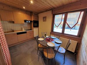 a kitchen with a table and chairs in a room at Appartement cosy aux Gets, idéal pour la famille, proche pistes et commerces - FR-1-598-104 in Les Gets