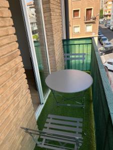 - Balcón con mesa blanca y 2 sillas en Apartamentos Garnacha 2 totalmente reformado, en Zaragoza