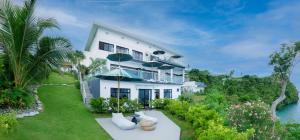 a large white house with a view of the water at Villa Escarceo in Puerto Galera