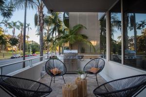 a balcony with two chairs and a kitchen with palm trees at Balboa II by AvantStay Modern Condo w Balcony Views of Balboa Park in San Diego