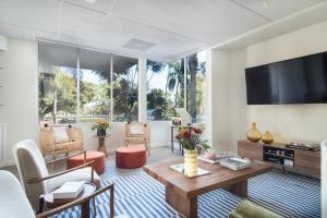 a living room with a table and a tv at Balboa II by AvantStay Modern Condo w Balcony Views of Balboa Park in San Diego