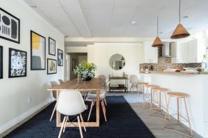 a kitchen and dining room with a wooden table and stools at Balboa II by AvantStay Modern Condo w Balcony Views of Balboa Park in San Diego