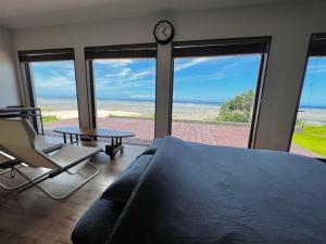 a bedroom with a bed and a table and a clock at ゴールデンマイルヴィラ in Amami