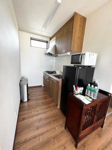 a small kitchen with a stove and a refrigerator at ゴールデンマイルヴィラ in Amami
