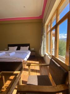 una camera da letto con due letti e una finestra di Rabyang Guest House and Homestay a Leh