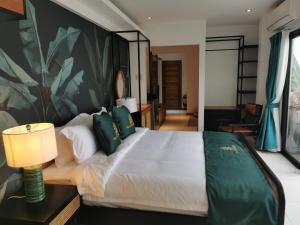 a bedroom with a large white bed with green pillows at Villa Escarceo in Puerto Galera