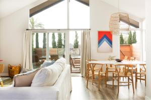 een woonkamer met een witte bank en een tafel bij Hamilton I by AvantStay Beach House Rooftop Deck Newly Renovated Bungalow in San Diego