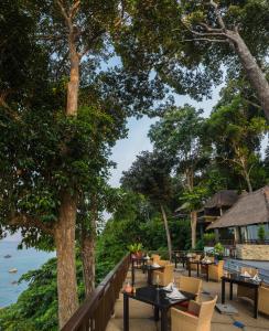 um restaurante com mesas e cadeiras junto à água em Banyan Tree Bintan em Lagoi