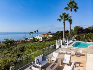 un complejo con piscina, sillas y palmeras en Vista by AvantStay Stunning Estate w Views of the Pacific Ocean Pool Spa, en San Diego