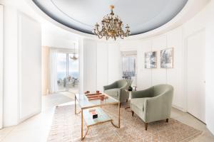 a living room with two chairs and a chandelier at Vista by AvantStay Stunning Estate w Views of the Pacific Ocean Pool Spa in San Diego