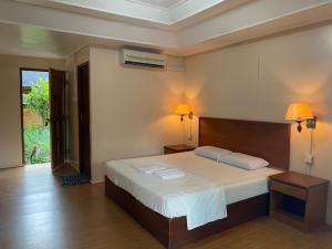 a bedroom with a large bed with two lamps on it at Cozy Resort in Perhentian Islands