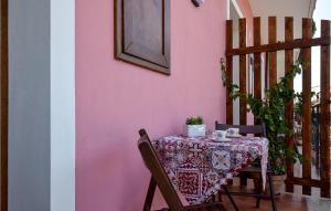 uma mesa com uma toalha de mesa numa parede cor-de-rosa em Awesome Apartment In Trappitello With Kitchen em Trappitello