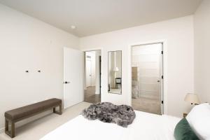 - une chambre blanche avec un lit et un miroir dans l'établissement Flexhome Brady District 1BR Apt E3 - READ INFO, à Milwaukee