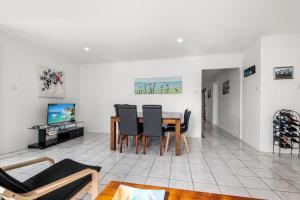 ein Wohnzimmer mit Esstisch und Stühlen in der Unterkunft Bell Street 36 Dicky Beach in Caloundra + 4 Fotos