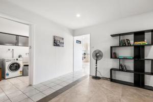 ein Wohnzimmer mit weißen Wänden und einer Mikrowelle in der Unterkunft Bell Street 36 Dicky Beach in Caloundra