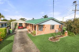 ein Haus mit einem grünen Dach und einer Auffahrt in der Unterkunft Bell Street 36 Dicky Beach in Caloundra