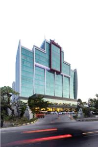 a large glass building with a street in front of it at Claro Hotel Kendari in Kendari