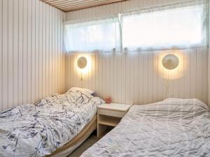 a small bedroom with a bed and a window at Holiday home Aakirkeby XXXII in Vester Sømarken