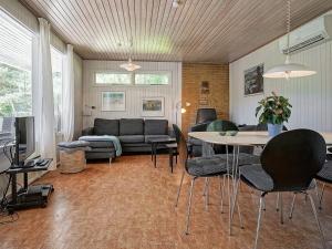 a living room with a couch and a table at Holiday home Aakirkeby XXXII in Vester Sømarken