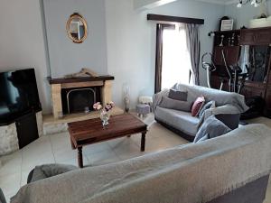 un soggiorno con un divano e un tavolino da caffè di Corfu Maisonette House ad Alepoú