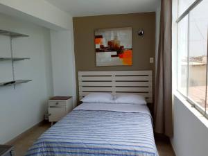 um quarto com uma cama e uma janela em Hospedaje Nuna - Playa Huanchaco em Huanchaco