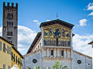 a church with a tower and a cross on top of it at Apartment in Lucca near Piazza Napoleone in Lucca