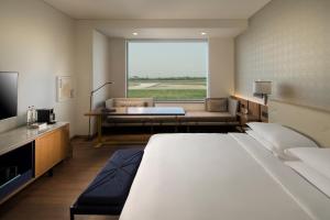 Pokój hotelowy z dużym łóżkiem i kanapą w obiekcie Andaz Delhi Aerocity- Concept by Hyatt w Nowym Delhi