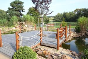 a wooden bridge over a pond with a rope fence at Sportpenzion Pohoda in Pilsen