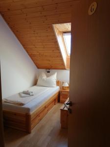 a bedroom with a bed in a attic with a window at Casa Ninfea Panzió in Cserszegtomaj