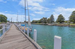 a dock with a sail boat in the water at Absolute in Port Fairy