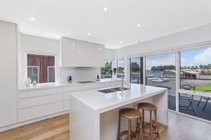 a kitchen with white cabinets and a counter with stools at Absolute in Port Fairy