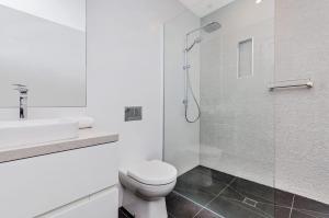 a bathroom with a toilet and a sink and a shower at Absolute in Port Fairy