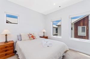a bedroom with a white bed with two towels on it at Absolute in Port Fairy