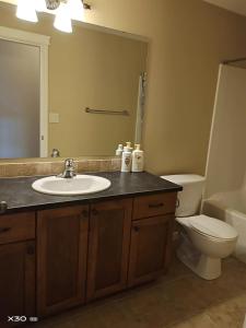 bagno con lavandino, servizi igienici e specchio di 1 bedroom lake Mountain view a West Kelowna
