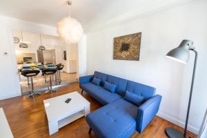 - un salon avec un canapé bleu et une table dans l'établissement KASA ZAMBEZE - Spacieux - WIFI, à Saint-Étienne